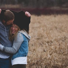 man and woman hugging on brown field